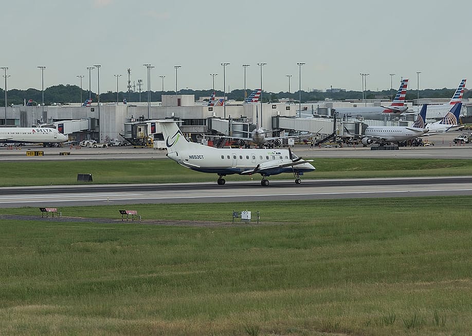 Airplanes are landing and taking off at the runway at the Charlotte Douglas International Airport with the city of Charlotte, North Carolina. — Phyllis Peterson // Shutterstock