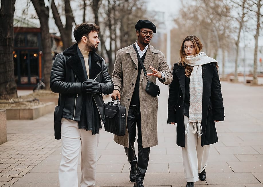 A group of stylish young entrepreneurs walking together outdoors engaged in a conversation. — Gorgev // Shutterstock