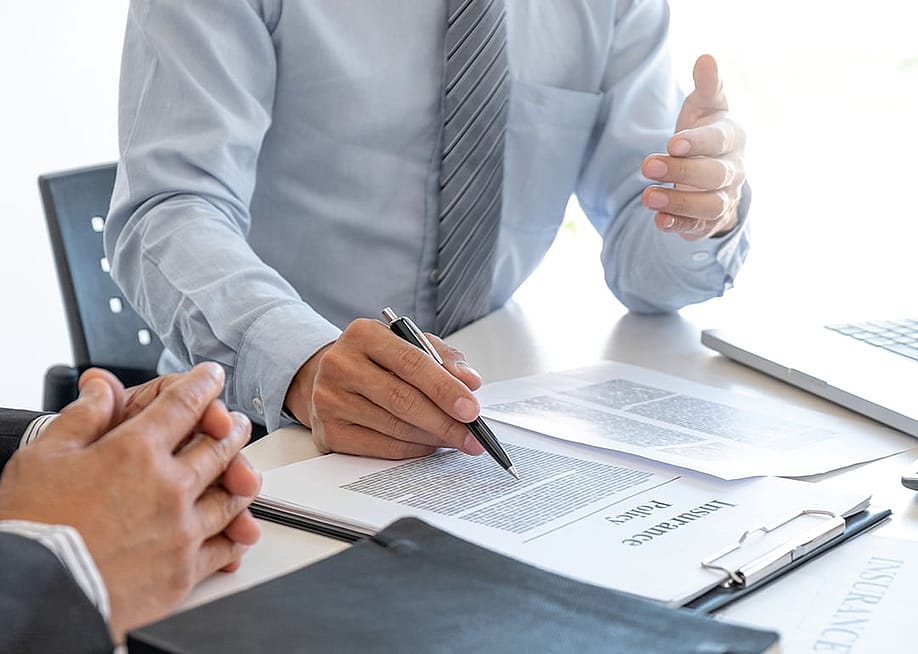 An insurance agent explaining a policy to a customer. — mojo cp // Shutterstock