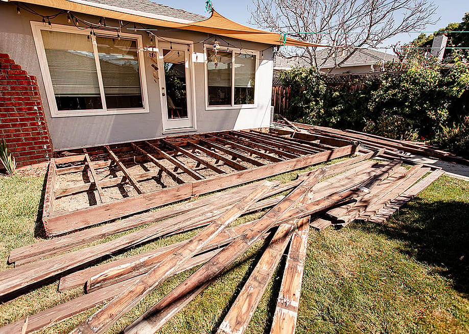 A pile of broken and old wooden lumber laying on the lawn backyard. — bluestork // Shutterstock