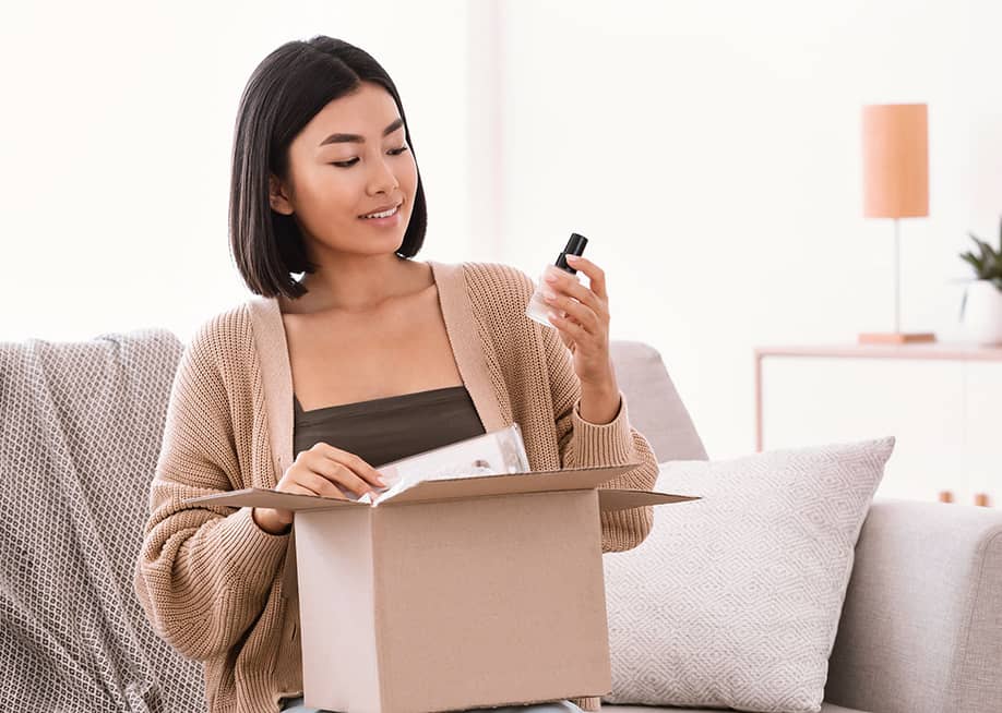 A young woman unboxing a package of makeup delivery. — Prostock-studio // Shutterstock