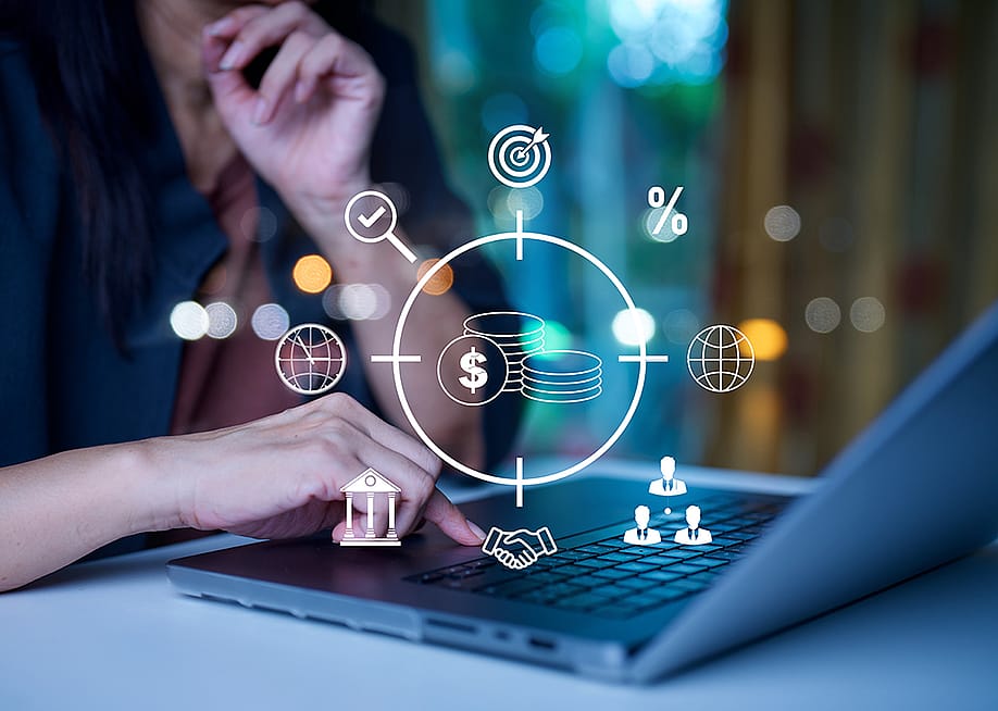 A businessman using a laptop illustrated with investment banking graphics. — Pornnapa Ausuwan // Shutterstock