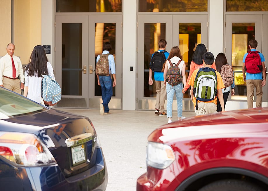 High school students being dropped off by their parents at their campus' entrance. — Monkey Business Images // Shutterstock