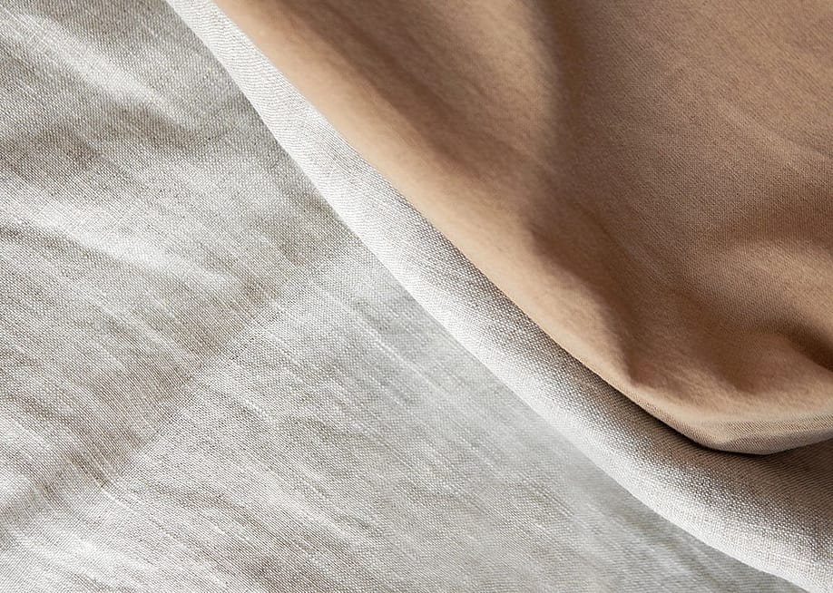 Folded linen cloths spread in a textured background. — 9gifts // Shutterstock