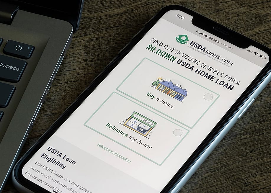 The homepage of the USDA loan program website on a smartphone. — Tada Images // Shutterstock