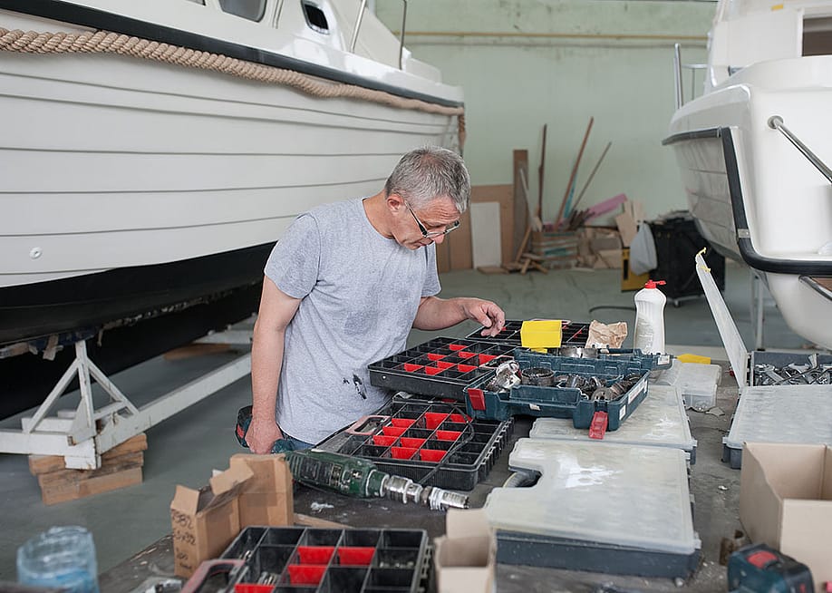 A person looking for an item on a tool box set for a boat repair. — pajtica // Shutterstock