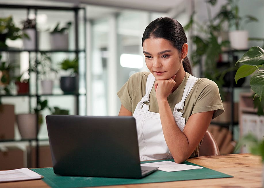 A female small business owner using a laptop to review files. — PeopleImages // Shutterstock