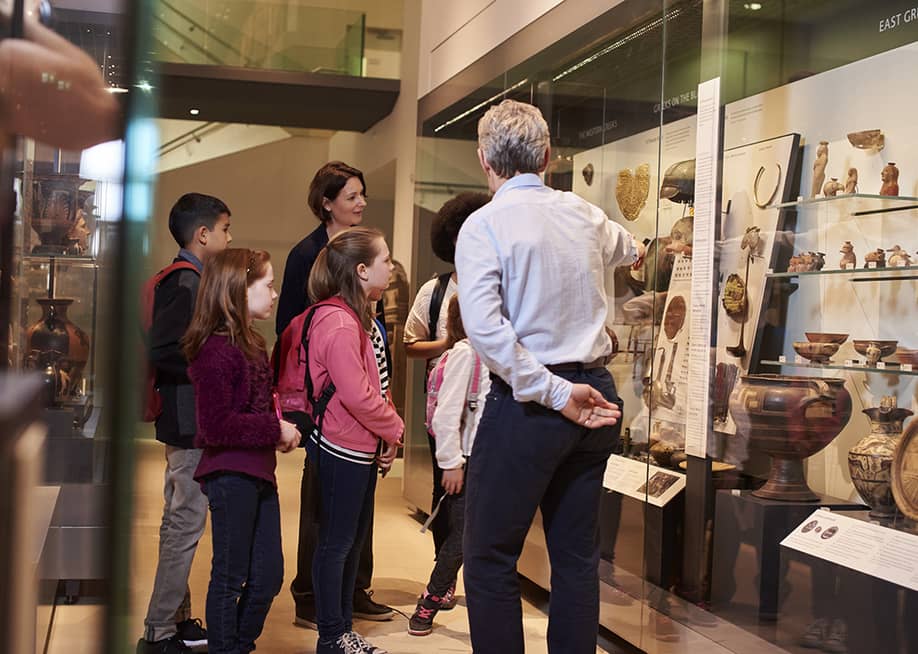 Students looking through artifacts during a museum visit. — Monkey Business Images // Shutterstock