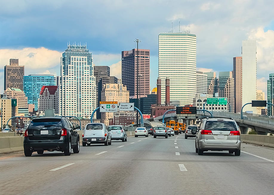 Cars driving to downtown area with the Boston skyline in the background. — Stefan Ugljevarevic // Shutterstock