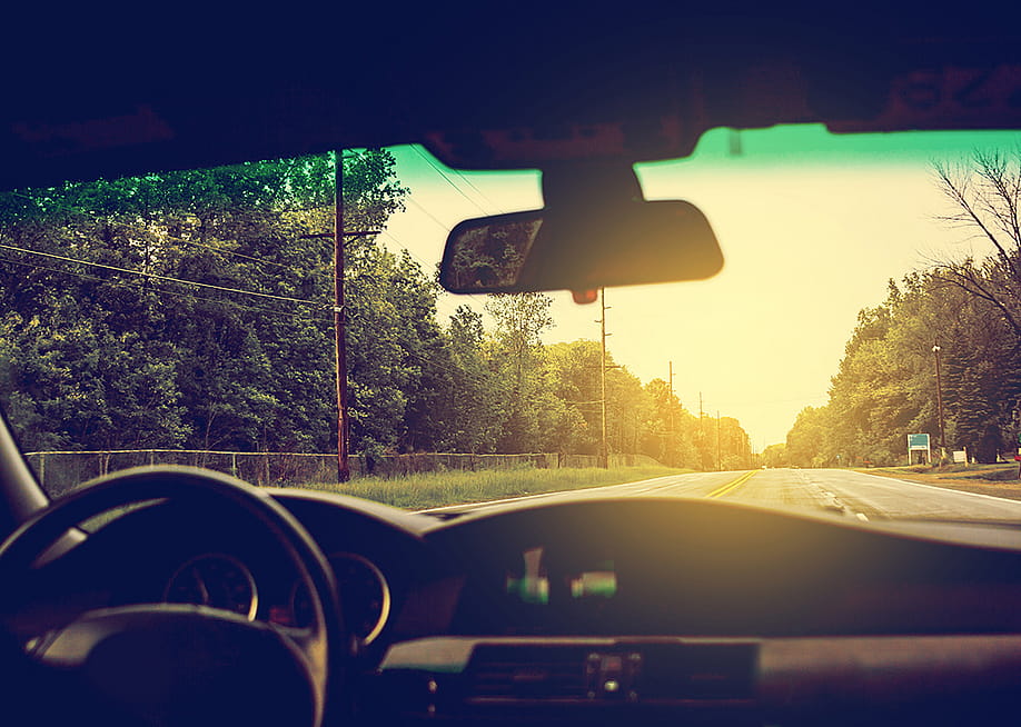 View from inside a car where sunlight is streaming through the windshield. — MaxyM // Shutterstock