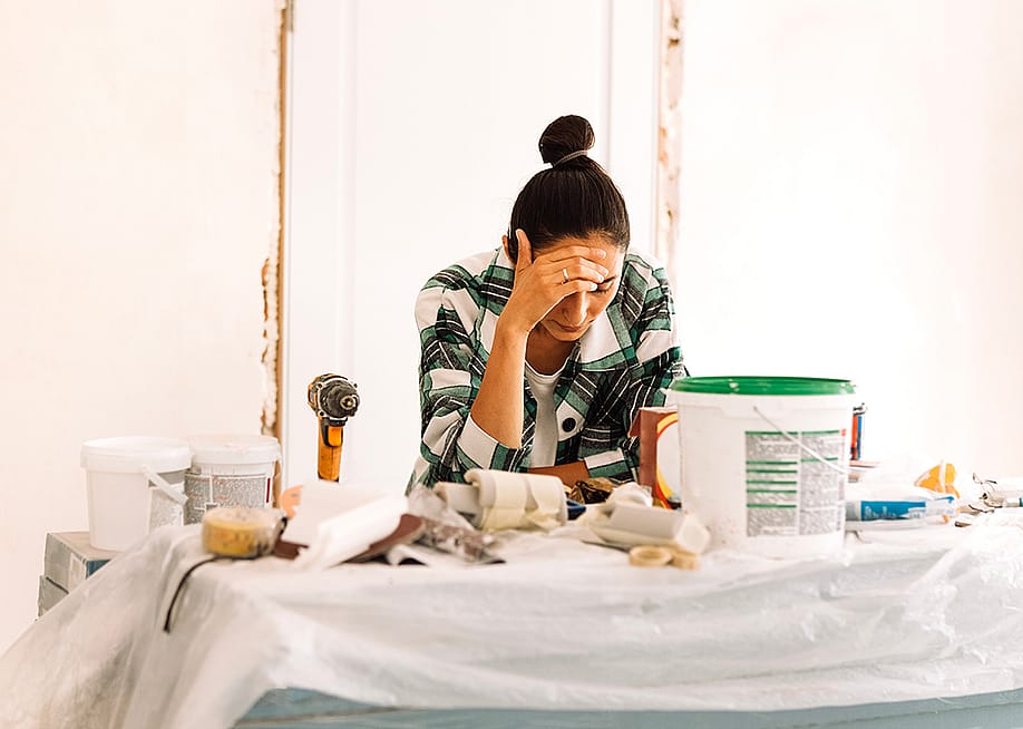 A young adult appearing to be tired from doing house painting and repairs. — Dasha Petrenko // Shutterstock