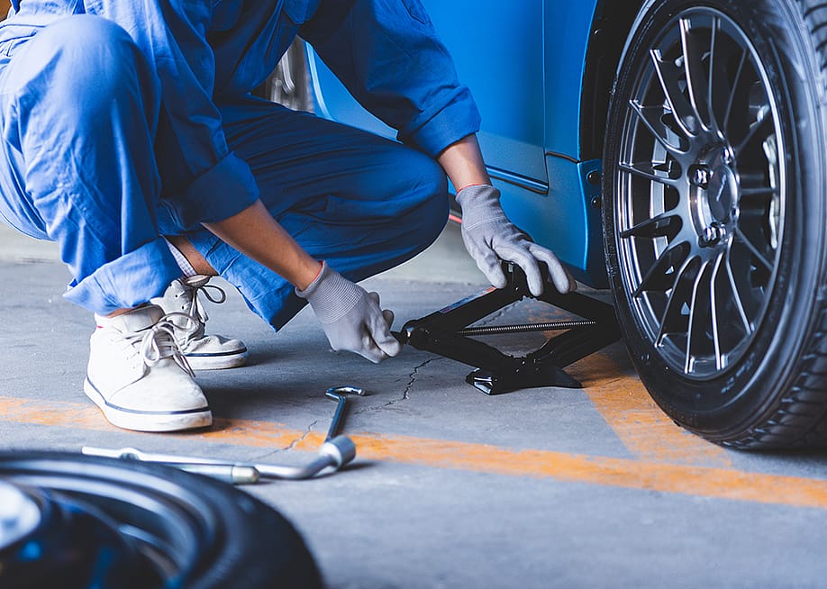 A car mechanic changing tires. — MiniStocker // Shutterstock