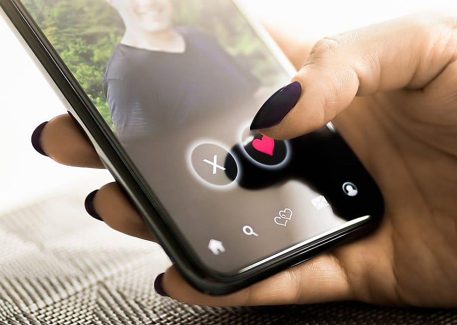 A person checking a profile of another person from a dating application in her smartphone. — Tero Vesalainen // Shutterstock
