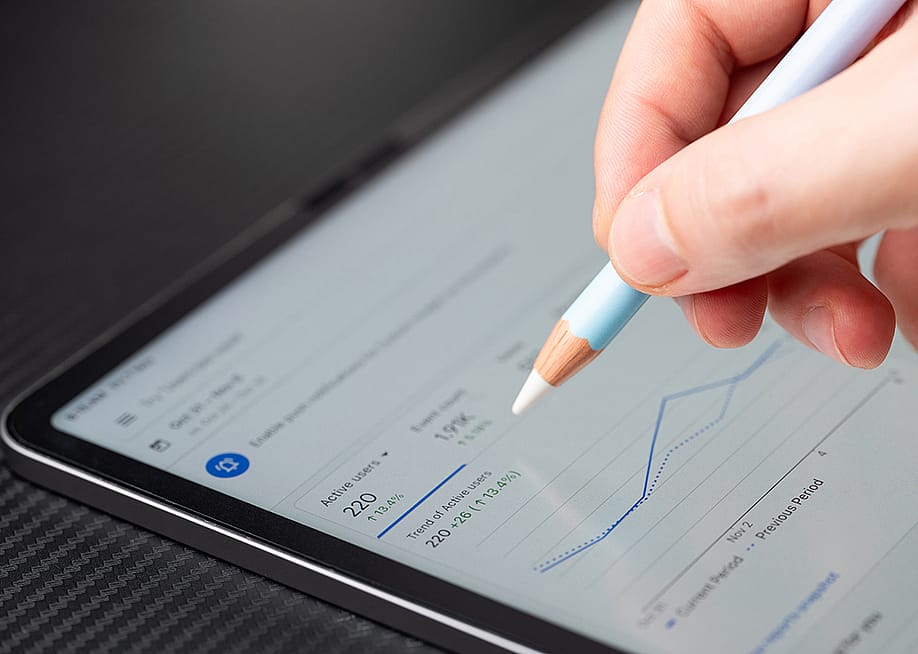 Person navigating Google Ads analytics dashboard on a tablet. — PixieMe // Shutterstock