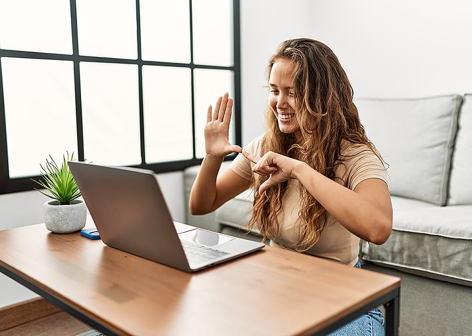 A person communicating through sign language during a Zoom video call. — Krakenimages.com // Shutterstock