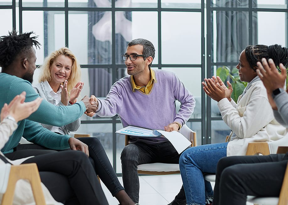A diverse business team huddling in an office. — Pro.Sto // Shutterstock