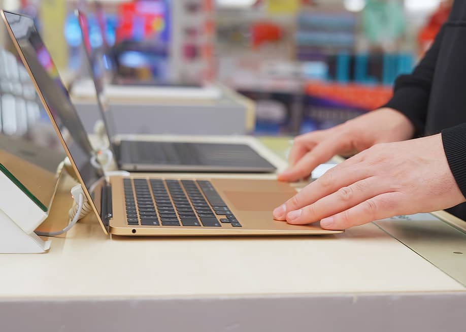 A student testing a brand new laptop at a store. — woff // Shutterstock