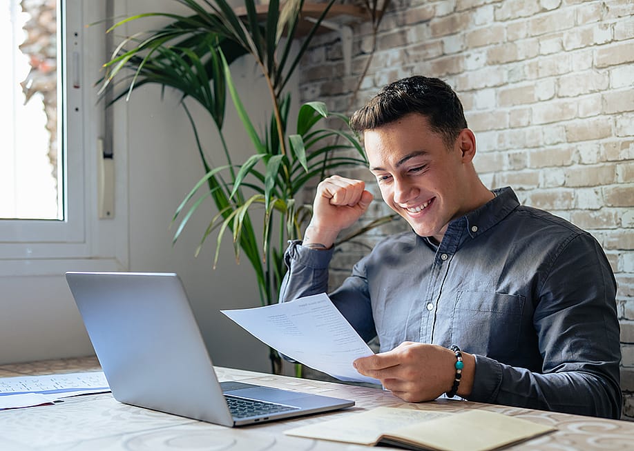 An excited businessman reading news from a letter. — PerfectWave // Shutterstock