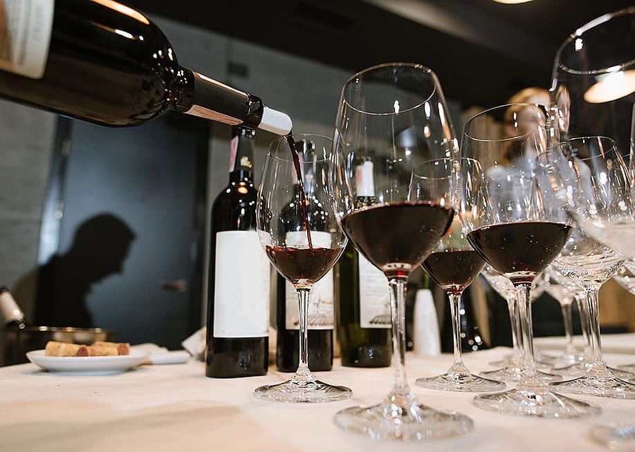 Wine being poured into glasses by a somelier at a restaurant. — Bolyuk Studio // Shutterstock