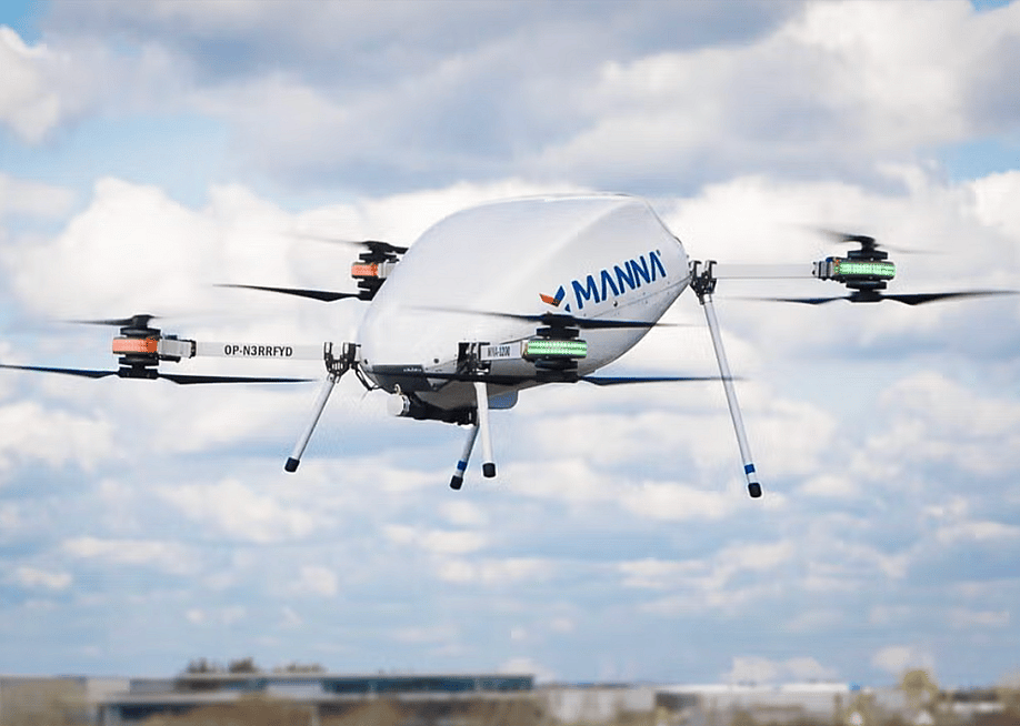 A Manna Air Delivery drone in action in the sky with clouds in the background. — Manna Air Delivery