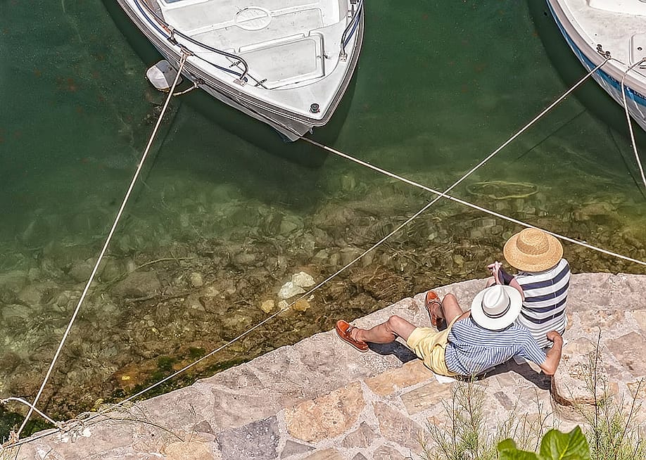 A senior couple relaxing by the lagoon. — Antony McAulay // Shutterstock