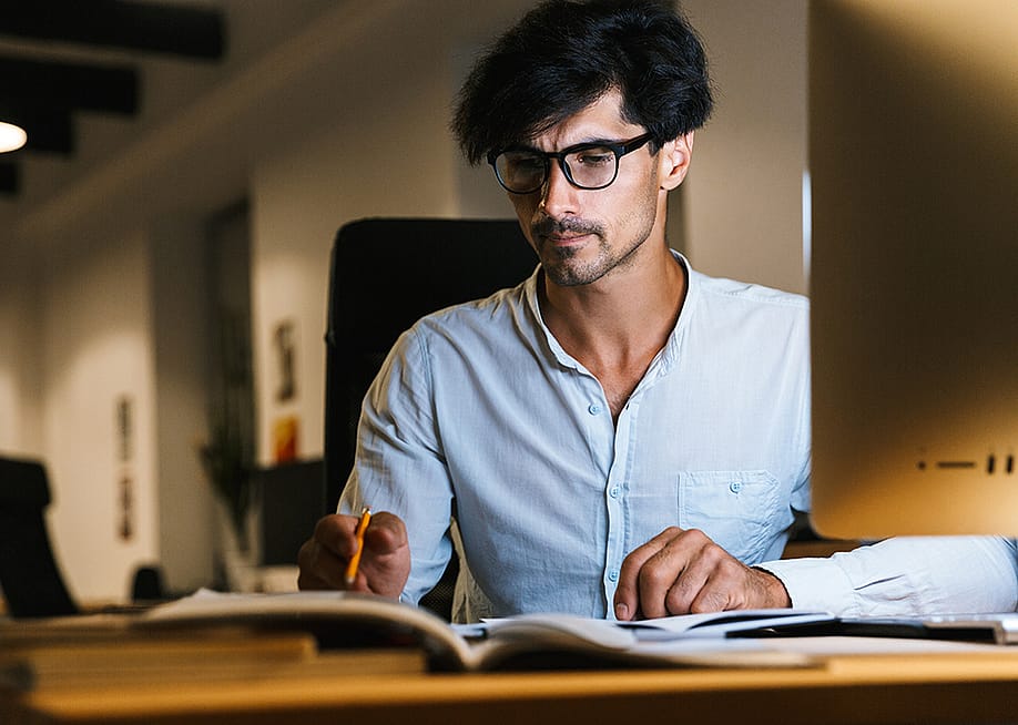 A focused businessman working at night. — Dean Drobot // Shutterstock