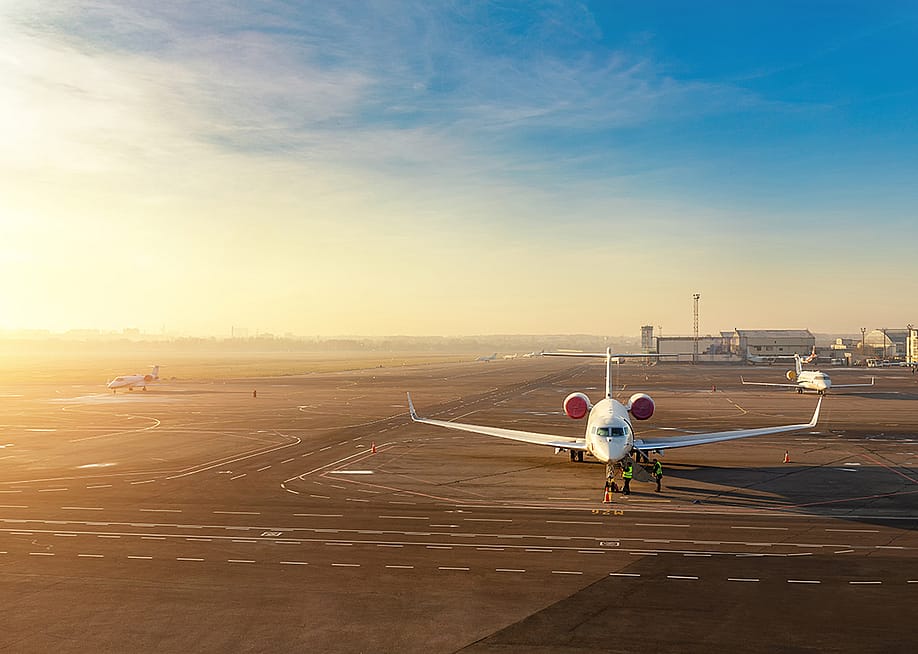 A private jet getting ready for a departure with a scenic sunset view in the background. — K-FK // Shutterstock