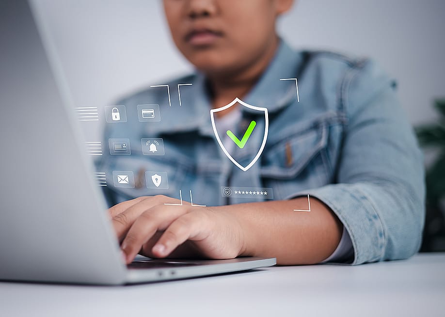 A teenage boy using the internet illustrated with cybersecurity and data privacy graphics. — UnImages // Shutterstock
