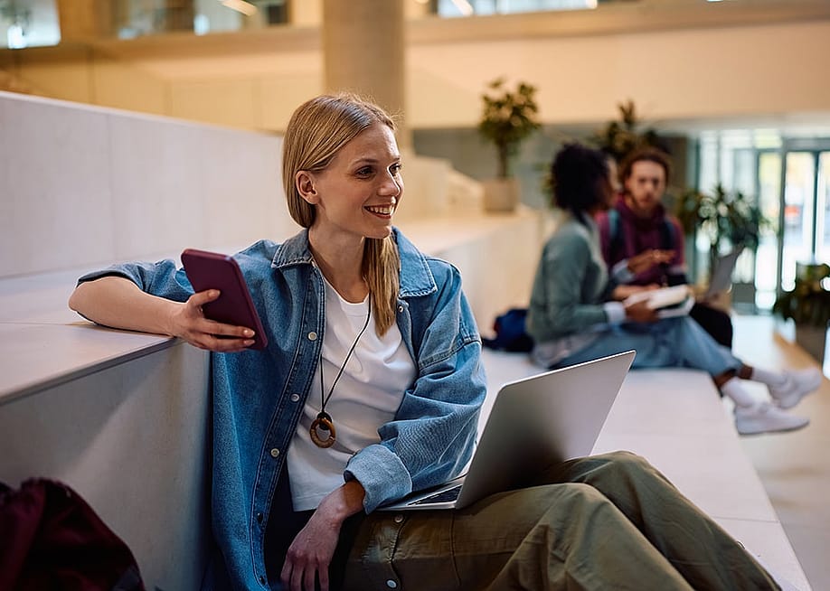 A college student enjoying her free time while reviewing class notes in the lecture hall. — Drazen Zigic // Shutterstock