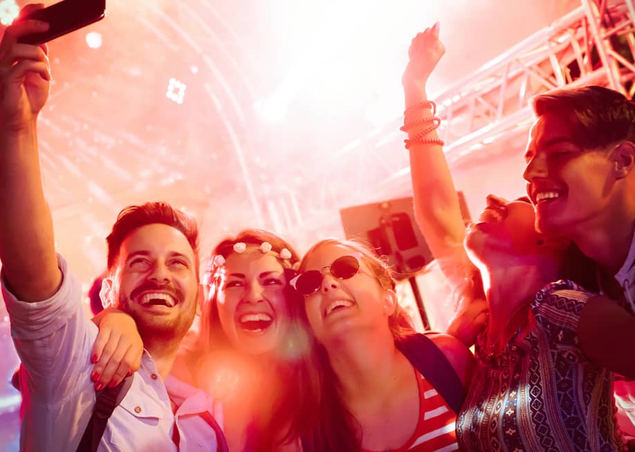 Friends enjoying a party night while taking videos in the club. — NDAB Creativity // Shutterstock