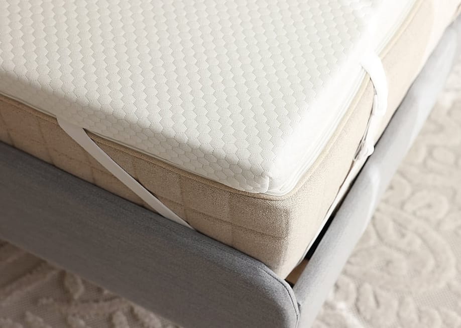 A grey bed with a brand new memory foam mattress. — New Africa // Shutterstock