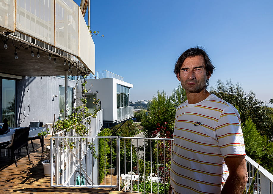 Aleksandar Jovanovic, a Airbnb landlord, stands on the deck of his Los Angeles home. His tenant, Elizabeth Hirschhorn, not pictured, is still living in his guesthouse listed on Airbnb, shown in background middle with a view of The Getty Center, after the lease ended nearly two years ago without paying rent. — Allen J. Schaben // Los Angeles Times via Getty Images