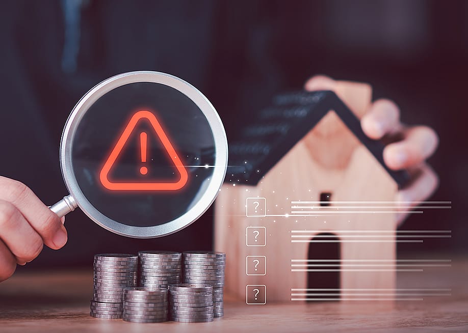 A financial analyst evaluating mortgage risk and housing uncertainty with miniature concepts. — chaylek // Shutterstock