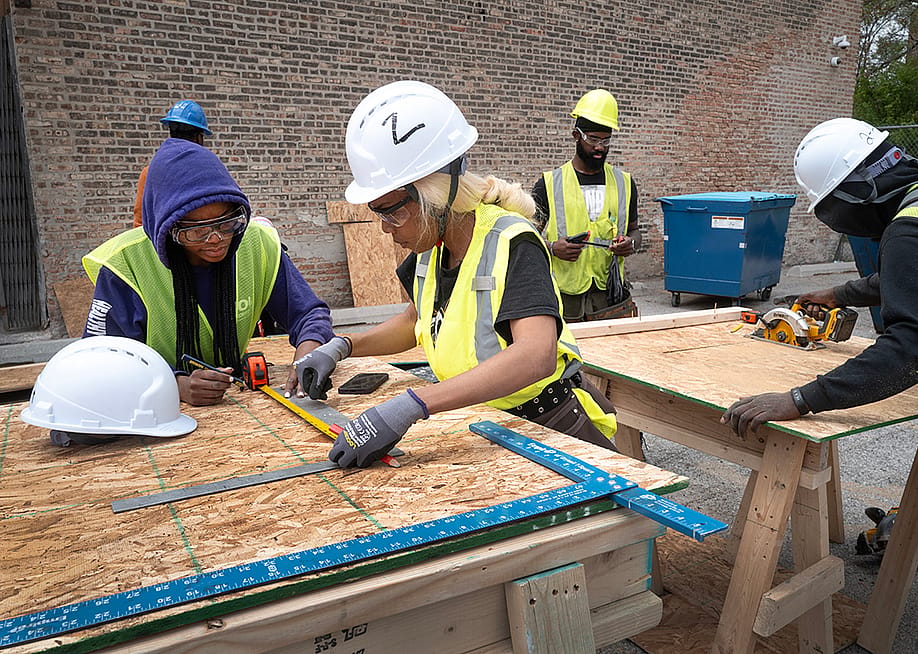 Male and female students learn construction skills at the Revolution Workshop, a non-profit training organization, in Chicago, Illinois. — Scott Olson // Getty Images