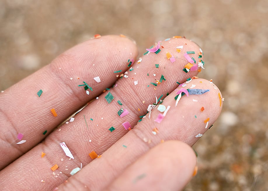 Micro plastics on a person's fingers. — Deemerwha studio // Shutterstock