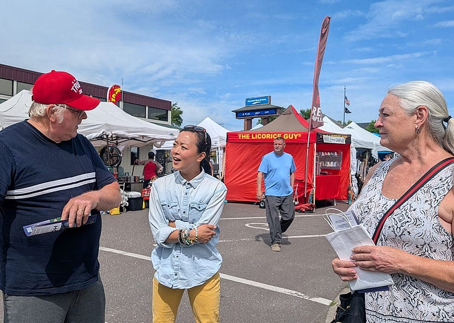 Wisconsin State Representative Francesca Hong speaking to voters Robert Olson and his wife during an outdoors festival. — Baylor Spears // Wisconsin Examiner