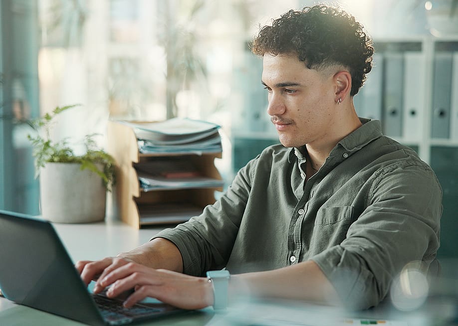 A male employee at work using a laptop. — PeopleImages // Shutterstock