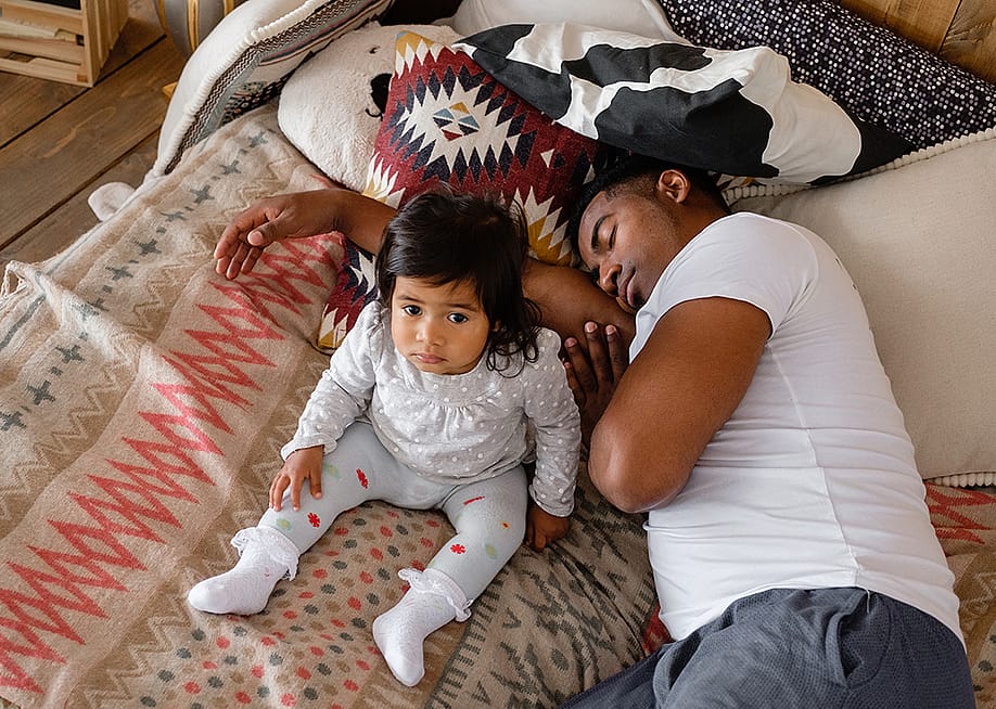 A father sleeps beside his young daughter. — GingerKitten // Shutterstock