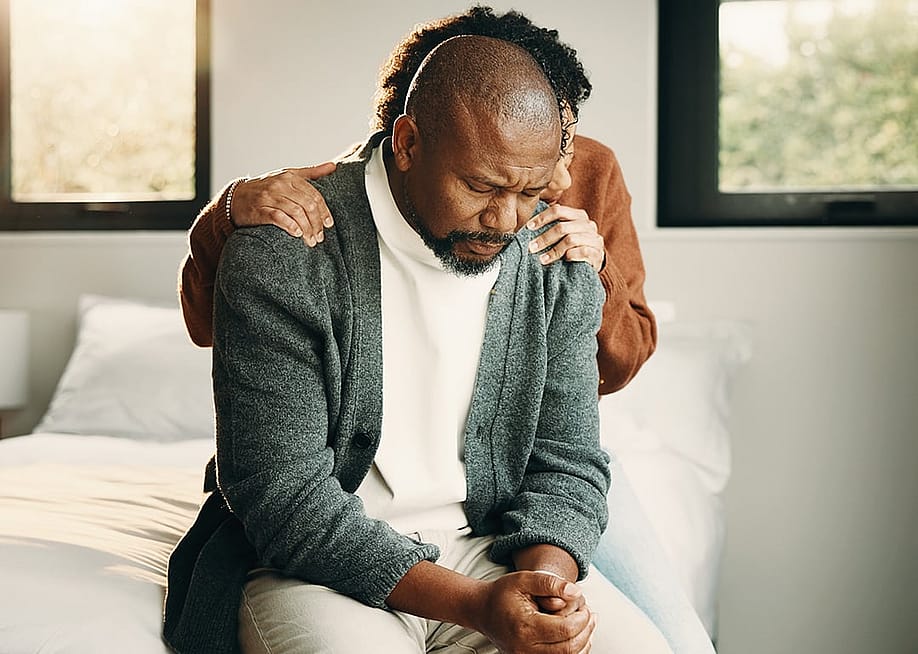 A sad couple comforting each other during a tough time. — PeopleImages // Shutterstock
