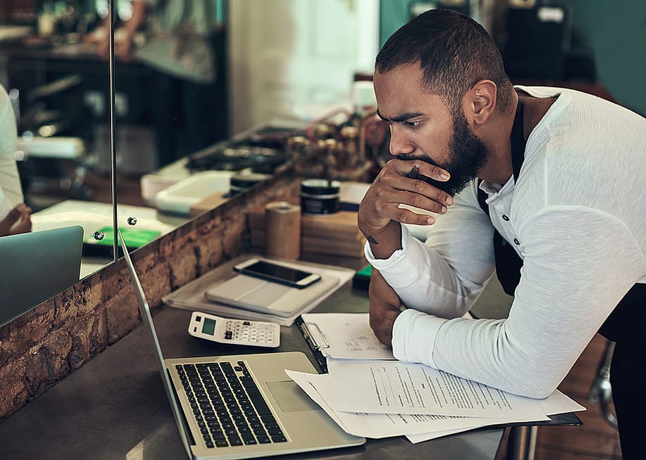 Owner of barbershop reviewing sales — PeopleImages // Shutterstock