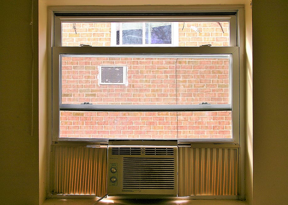 An air conditioning installed through a window. — Marie Kelleher // Shutterstock