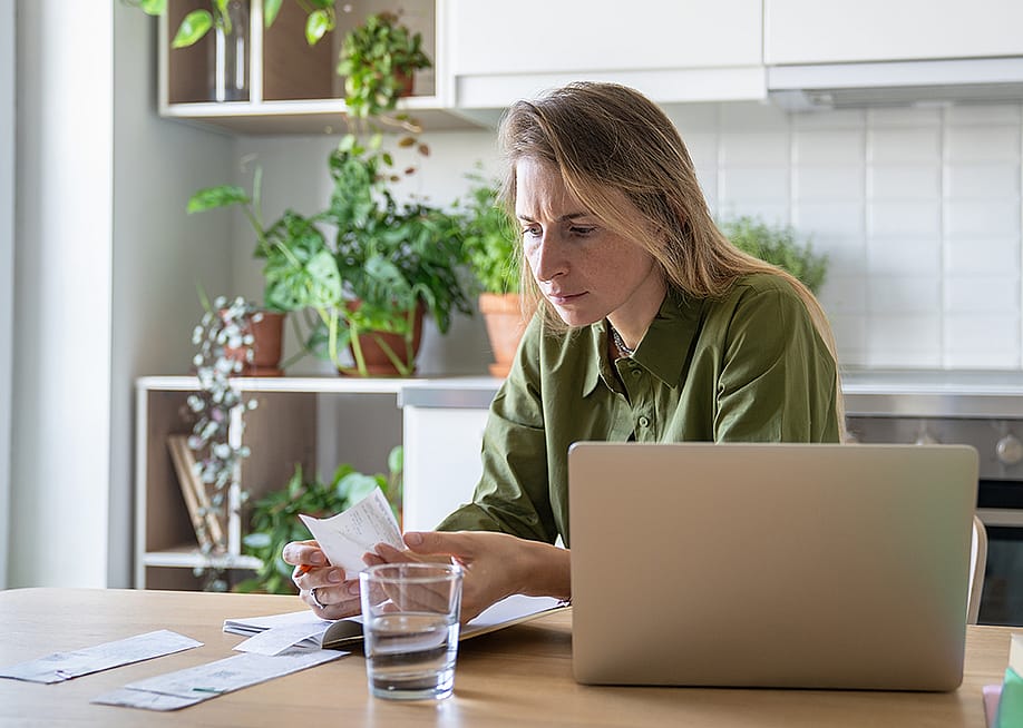 A person checking receipts and financial statements from different expenses at home. — DimaBerlin // Shutterstock