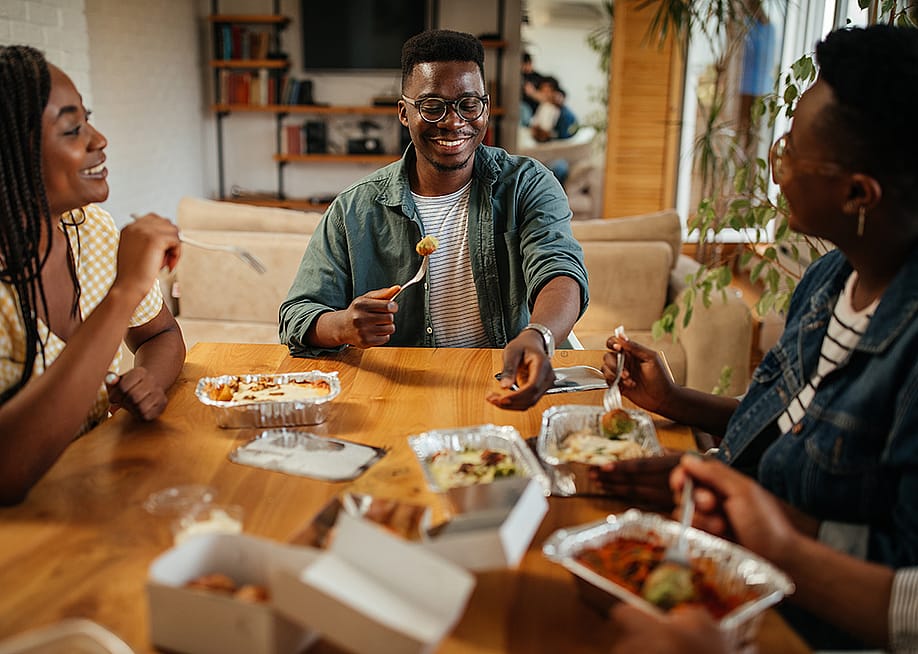 A group of friend enjoying takeaway at home. — bbernard // Shutterstock