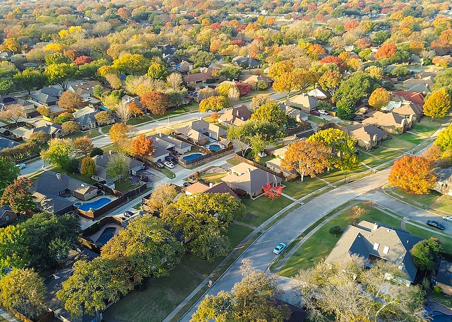 An aerial view of a suburban residential neighborhood during autumn season. — Trong Nguyen // Shutterstock