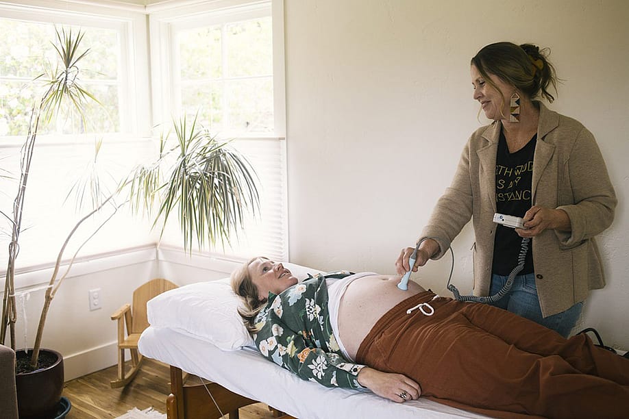 Midwife Laura Doyle listens to Leslie Booher’s baby’s heartbeat using a fetal doppler during an exam at Moonstone Midwives Birth Center on Monday, May 4, 2026 in Eureka, California. — Alexandra Hootnick for KQED