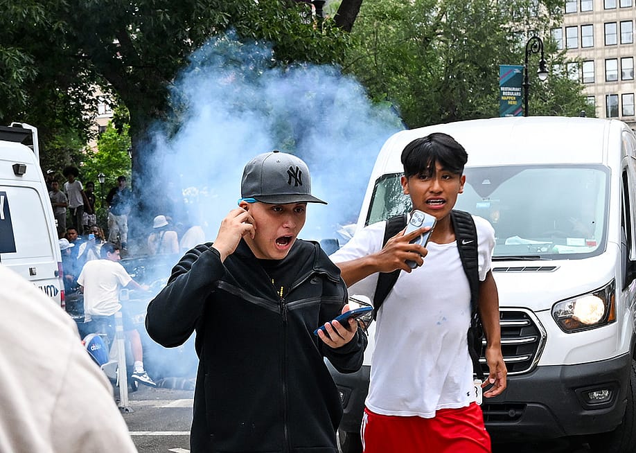 Teenagers run away after an unknown explosive device is set off during popular Twitch streamer Kai Cenat's event in New York City on August 4, 2023. — Alexi J. Rosenfeld // Getty Images