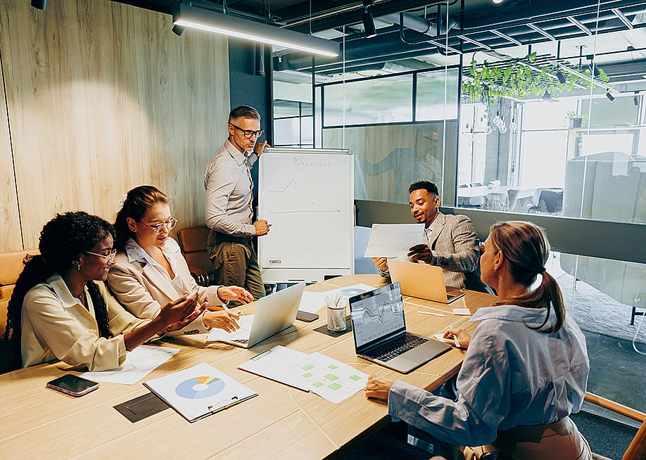 A business team brainstorming and discussing a report. — Kostiantyn Voitenko // Shutterstock