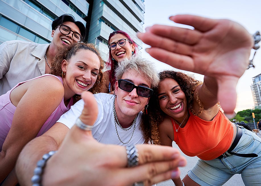 A group of Gen Z friends taking a selfie together outdoors. — Gigi Delgado // Shutterstock
