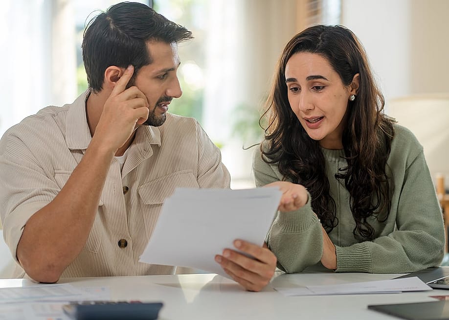 A couple discussing insurance paperwork — creveleo // Shutterstock