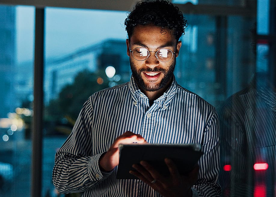 A finance consultant analyzing stock market data from his work tablet in the office. — PeopleImages // Shutterstock